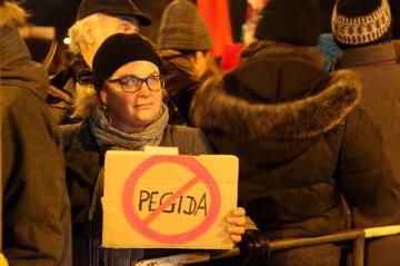 Ein Demonstrant hält ein Plakat auf dem "Pegida" durchgestrichen ist in den Händen. Gegendemonstration unter dem Motto "Köln stellt sich quer". Kögida/Pegida ("Patriotische Europäer gegen die Islamisierung des Abendlandes") Demonstration in Köln am 5. Januar 2015.