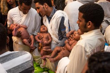 Diakone der eritreisch-orthodoxen Gemeinde Sankt Michael halten nackte Säuglinge in den Händen bei der Taufe am 25. Februar 2018 in der evangelischen Kreuzkirche in Hamburg.