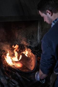 Der Schmied Georg Schmidberger steht vor einem lodernden Feuer am 18. April 2018 in seiner Schmiede in Molln (Österreich).