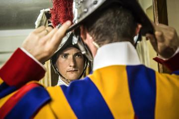 Ein Schweizergardist probiert einen neuen Helm an in der Waffenkammer der Päpstlichen Schweizergarde im Vatikan am 27. April 2018 und betrachtet sich dabei im Spiegel.