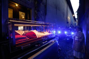 Der gläserne Sarg mit dem Leichnam des heiligen Papstes Johannes XXIII. wird am 24. Mai 2018 auf der Ladefläche eines Pick-ups während einer Prozession durch Bergamo gefahren. Hinter dem Sarg fahren Polizisten mit Motorrädern.
