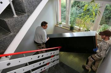 Haushaltsauflösung durch Mitarbeiter der Arche in Bonn am 21. September 2015. Die Arche in Bonn bietet berufliche Reintegration von Langzeitarbeitslosen und behinderten Menschen. Bild: Mitarbeiter tragen einen Schrank die Treppe runter.