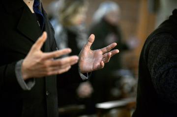 Ein Gottesdienstteilnehmer hält die Hände mit den Handflächen nach oben, während er das Vaterunser betet, am 1. März 2017 in der Kirche Saint-Denys-du-Saint-Sacrement in Paris.