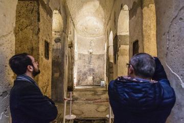 Touristen besichtigen die antike, unterirdische Basilica sotterranea di Porta Maggiore in Rom am 14. Januar 2018. Putz bröckelt von den Säulen, Wänden und Decke.