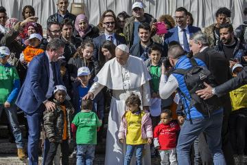 Kinder in bunten T-Shirts, Jugendliche, Männer und Frauen, unter anderem mit Kopftuch stellen sich gemeinsam mit Papst Franziskus zu einem Gruppenfoto auf, während der Generalaudienz am 14. März 2018 im Vatikan.