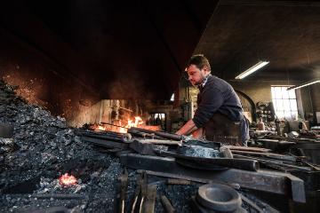 Der Schmied Georg Schmidberger arbeitet an einem lodernden Feuer am 18. April 2018 in seiner Schmiede in Molln (Österreich).