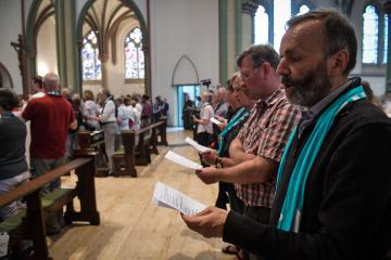 Teilnehmer eines Gottesdienstes halten Liederzettel in den Händen und singen in der Heilig Kreuz Kirche am 12. Mai 2018 in Münster.
