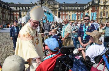 Kardinal Reinhard Marx, Vorsitzender der Deutschen Bischofskonferenz (DBK), spricht mit einem Mann im Rollstuhl auf dem 101. Deutschen Katholikentag am 13. Mai 2018 in Münster.