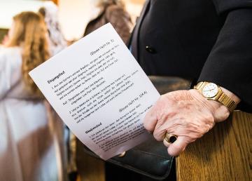 Die Hand einer alten Frau hält am 29. April 2018 bei einem Gottesdienst in der Kirche Sankt Martin in Dietzenbach ein Liedblatt.