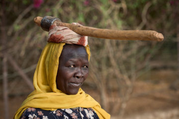 Eine Frau trägt am 27. April 2018 in Gidel (Sudan) ein Beil auf dem Kopf.
