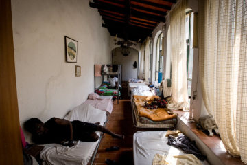 Menschen liegen auf Betten in einem Korridor am 25. August 2018 in Pistoia (Italien). Die lokale katholische Gemeinde hat die Herberge für obdachlose Flüchtlinge eingerichtet.