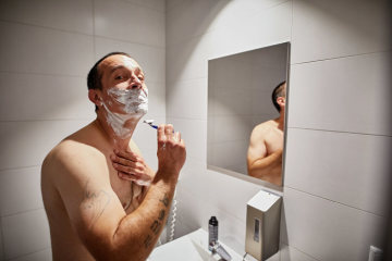 Ein Mann rasiert sich nass vor dem Spiegel im Hygienecenter Berlin am 6. September 2018 in Berlin.
