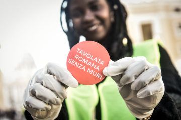 Eine farbige Frau zeigt das Logo der Veranstaltung "Tavolata Romana Senza Muri" (Römischer Tisch ohne Mauern), ein gemeinsames Essen gegen Diversität und Rassismus auf den Straßen von Rom am 20. Oktober 2018.