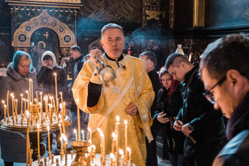 Ein Diakon schwenkt ein Rauchfass zwischen Kerzenaltären und Gottesdienstbesuchern während eines ukrainisch-orthodoxen Gottesdienstes des Kiewer Patriarchats am 28. Oktober 2018 in der gefüllten Kathedrale Wladimir in Kiew.