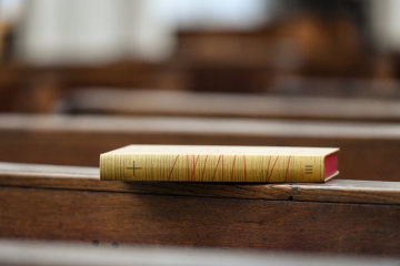 Ein Lektionar mit Texten in der revidierten Einheitsübersetzung liegt am 13. November 2018 auf einer Kirchenbank in einer Kirche in Bonn.
