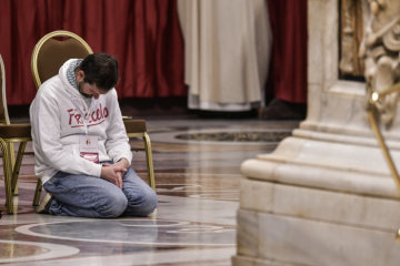 Ein Gottesdienstteilnehmer kniend im Gebet versunken bei der Papstmesse im Petersdom zum katholischen "Welttag der Armen" am 18. November 2018 im Vatikan.