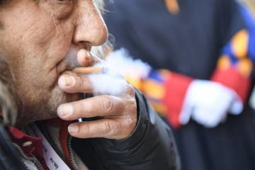 Ein Teilnehmer raucht beim Mittagessen mit Papst Franziskus zum katholischen "Welttag der Armen" am 18. November 2018 im Vatikan.
