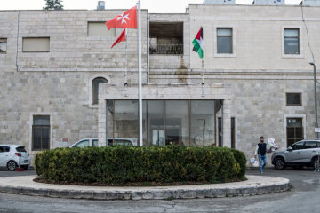 Flaggen der Werke des Malteserordens und der palästinensischen Autonomiegebiete wehen am Eingang des Holy Family Hospital (dt. Malteserkrankenhaus zur Heiligen Familie) in Bethlehem am 14. November 2018.