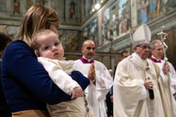 Eine Frau mit einem kleinen Kind auf dem Arm beim Gottesdienst zum Fest der "Taufe des Herrn" mit Papst Franziskus in der Sixtinischen Kapelle im Vatikan am 13. Januar 2019.