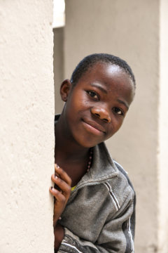 Ein traumatisiertes Mädchen blickt um eine Hausecke in Bukavu (Kongo) am 3. Mai 2018. Sie nimmt am OLAME-Projekt für verstoßene "Hexenkinder" teil.