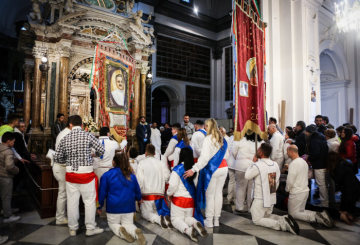 In weiß gekleidete Männer und Frauen stehen und knien auf dem Boden vor dem Bild der Madonna dell'Arco im Santuario di Madonna dell'Arco zu Ostern am 2. April 2018 in Sant'Anastasia (Neapel).