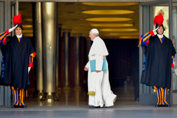 Papst Franziskus geht am 21. Februar 2019 im Eingang zur Synodenaula im Vatikan an zwei salutierenden Schweizergardisten vorbei.