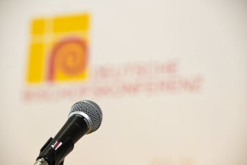 Ein Mikrofon vor dem Logo der Deutschen Bischofskonferenz (DBK) am 11. März 2019 in Lingen.