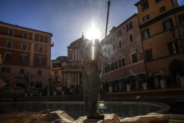 Ein Mann schiebt am 15. März 2019 Münzen in die Mitte des Trevibrunnens in Rom.