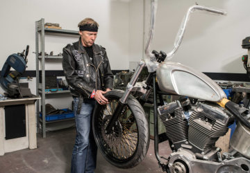 Pfarrer Johannes Matthias Roth, ein Mitglied des Motorradclubs der Jesus Biker, arbeitet in seiner Lederkutte am 26. Januar 2019 in der Werkstatt in Hettstadt an einer Harley Davidson für Papst Franziskus.
