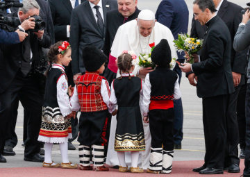 Papst Franziskus wird bei seiner Ankunft auf dem Flughafen von Sofia am 5. Mai 2019 von Kindern in traditioneller Kleidung begrüßt.