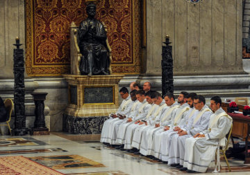 Die Weihekandidaten in weißen Alben sitzen auf einer Kirchenbank am 12. Mai 2019 im Petersdom im Vatikan.