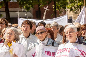 Frauen mit einem Plakat "Erneuert die Kirche" bei einer Mahnwache der Initiative "Maria 2.0" am 12. Mai 2019 vor dem Dom in Münster.