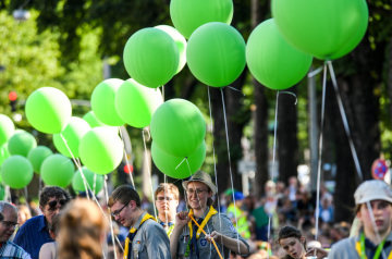Pfadfinder halten grüne Luftballons bei der Eröffnung des Deutschen Evangelischen Kirchentags (DEKT) am 19. Juni 2019 in Dortmund. Eine Pfadfinderin lacht in die Kamera.