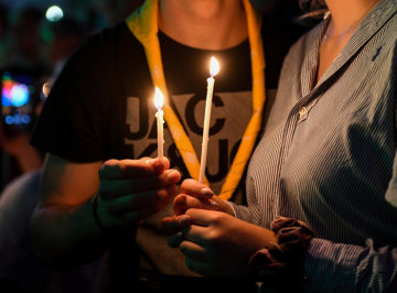 Menschen halten brennende Kerzen in den Händen, am 19. Juni 2019 in Dortmund.