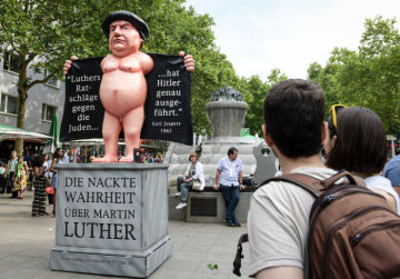 Die Figur Luthers, nackt unter dem geöffneten Umhang, auf einem Sockel stehend, ist am 22. Juni 2019 von Kirchentagsgegnern aufgestellt worden, auf dem Deutschen Evangelischen Kirchentag (DEKT) in Dortmund.