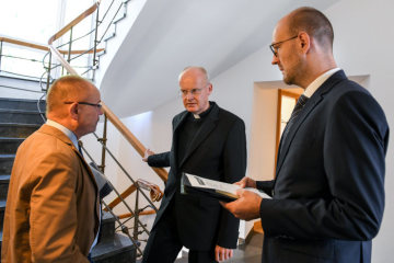 Franz-Josef Overbeck (m.), Bischof von Essen, während einer Besprechung mit Mitarbeitern im Treppenhaus des Bischofshauses in Essen am 2. September 2019.