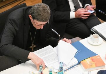 Kardinal Rainer Maria Woelki, Erzbischof von Köln, liest in einem Dokument bei den Beratungen der Synodalversammlung am 31. Januar 2020 im Dominikanerkloster in Frankfurt. Vor ihm liegt eine Bibel mit dem Logo des Synodalen Wegs.