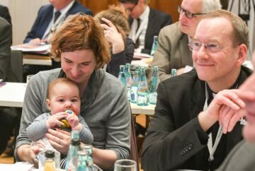Eine Frau mit Baby auf dem Schoß bei den Beratungen der Synodalversammlung am 31. Januar 2020 im Dominikanerkloster in Frankfurt.