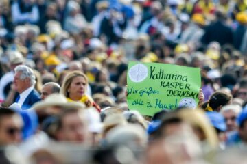 Menschen halten ein Plakat mit der Aufschrift "Katharina Kasper Dernbach. Wir grüßen alle zu Hause!" bei der Heiligsprechung von Maria Katharina Kasper, Gründerin der Kongregation der Armen Dienstmägde Jesu Christi, und sechs weiteren Seligen, am 14. Oktober 2018 im Vatikan.