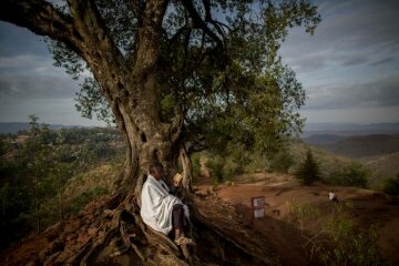 Ein äthiopisch-orthodoxer Christ betet unter einem Baum oberhalb der Felsenkirchen von Lalibela am 28. April 2016.
