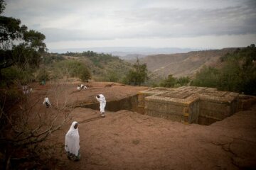 Bet Giyorgis, eine der elf Felsenkirchen in Lalibela am 28. April 2016. Äthiopisch-orthodoxe Christen sitzen und stehen auf dem Felsen, aus dem die Kirche herausgemeißelt wurde.