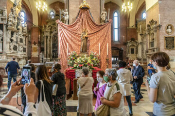 Pilger stehen vor dem mit Blumen geschmückten Altar mit der Holzstatue des heiligen Antonius von Padua, beim Fest des heiligen Antonius von Padua, in der Basilika Sant Antonio di Padova am 13. Juni 2020 in Padua.