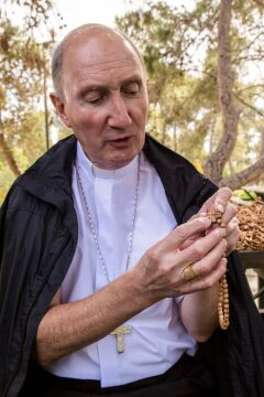 Peter Bürcher, emeritierter Bischof von Reykjavik, hält am 5. Februar 2018 in Bethlehem einen fertigen Rosenkranz aus Olivenholz in den Händen und erklärt die Gravuren.