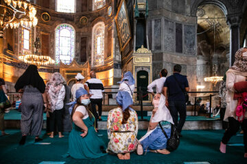 Touristen, darunter Frauen mit Kopftuch, Mundschutz und langem Rock, besuchen die Hagia Sophia am 5. September 2020 in Istanbul.