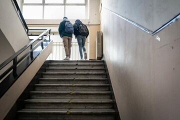 Schülerinnen und Schüler mit Masken gehen eine Treppe hoch, nach der Wiedereröffnung des Gymnasiums Giulio Cesare am 18. Januar 2021 in Rom.