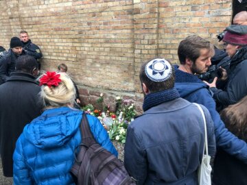 Menschen gedenken mit Blumensträußen und Kerzen an der Mauer der Synagoge in Halle (Saale) am 10. Oktober 2019 nach dem Anschlag am Tag zuvor.