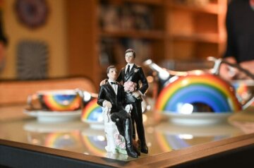 Auf einem Tisch steht eine Figur mit zwei Männern als Hochzeitspaar und ein Teeservice am 30. Oktober 2021 in Essen. Auf dem Teeservice ist die Regenbogenfahne aufgedruckt.