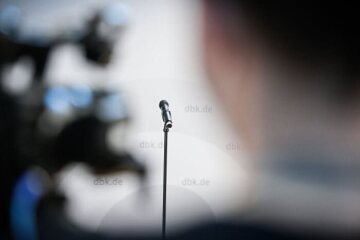 Ein Mikrofon während der Frühjahrsvollversammlung der Deutschen Bischofskonferenz (DBK) am 7. März 2022 in Vierzehnheiligen. Im Hintergrund ist das Logo der DBK zu sehen.