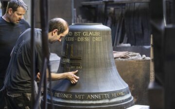 Arbeiter verzieren eine sogenannte "falsche" Glocke (die Innenform aus Lehm) mit Wachsbuchstaben bei der Produktion einer Glocke, am 22. April 2022 in der Werkstatt der Glocken- und Kunstgießerei Rincker in Sinn.