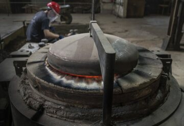 Ein Arbeiter an einem Schmelzofen bei der Produktion einer Glocke am 22. April 2022 in der Werkstatt der Glocken- und Kunstgießerei Rincker in Sinn.